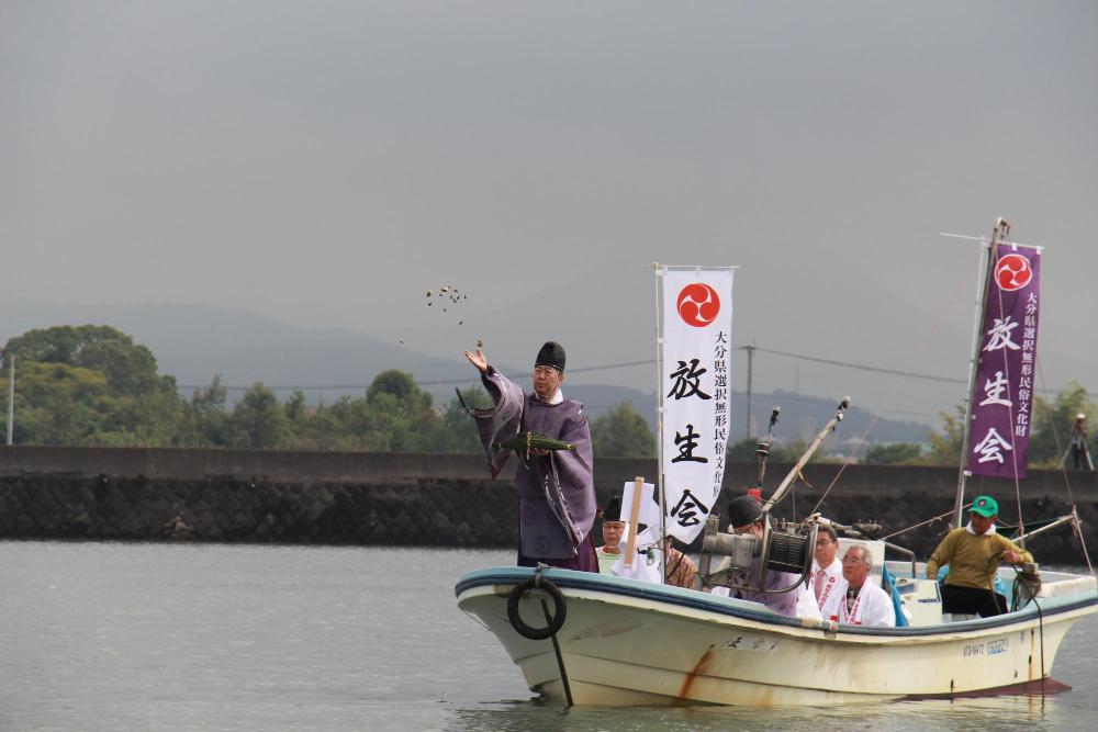 A priest releasing mollusks into the river during the Nina Hojo ritual