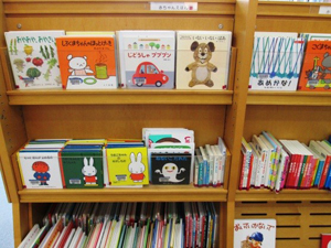 本棚に赤ちゃん向けの沢山の本が表紙が見える状態で並べられている写真の画像