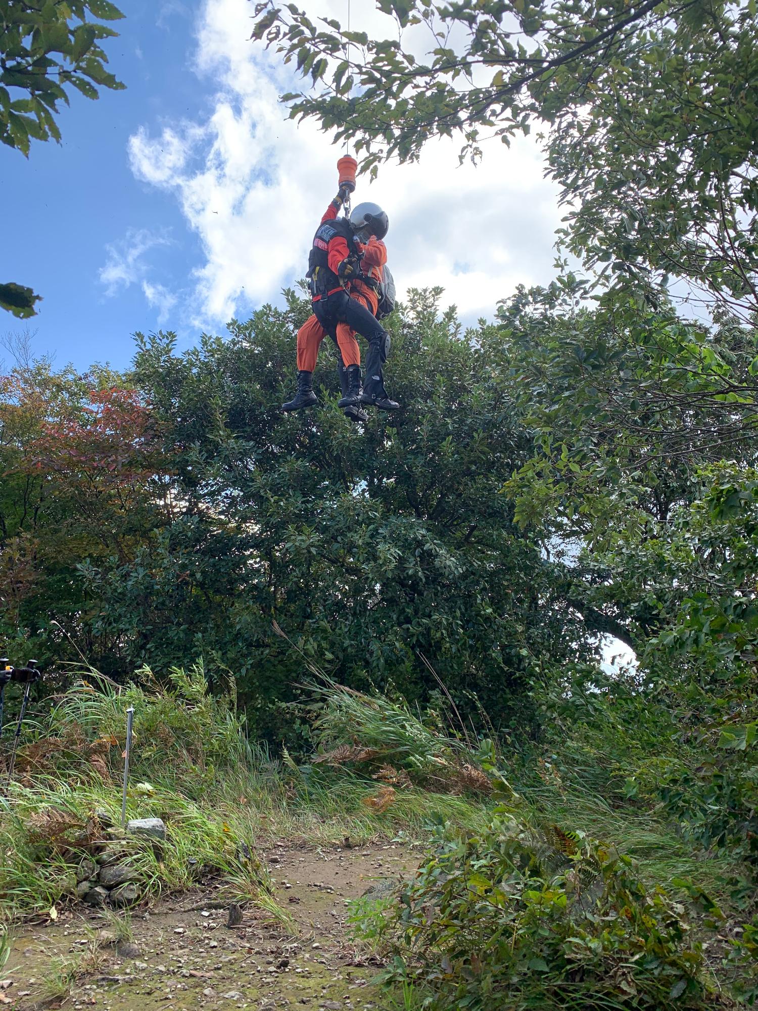 防災ヘリから山頂に降下する隊員