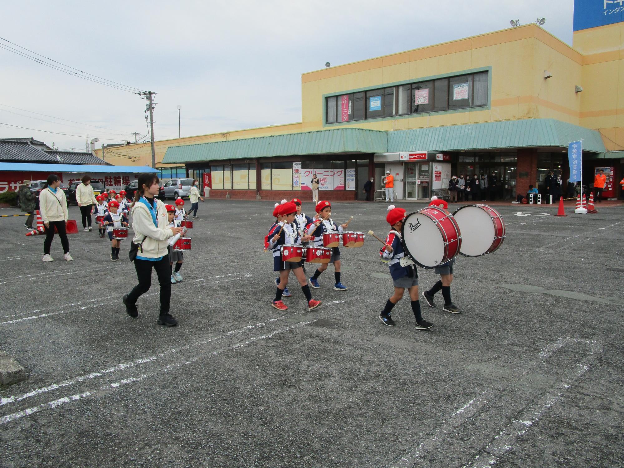 大太鼓や小太鼓を持ってマーチングする園児たちの写真