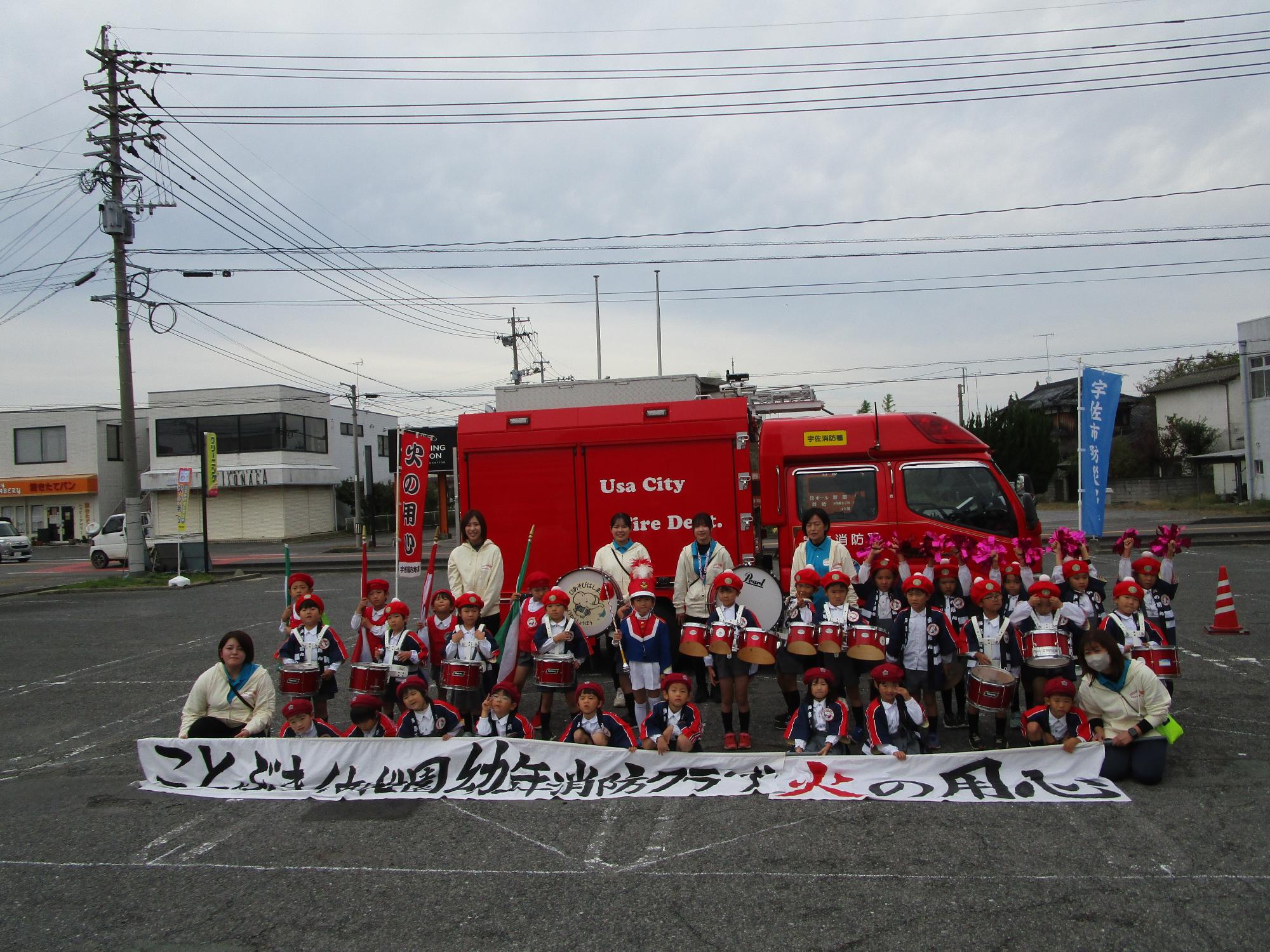消防車の前で記念写真を撮る園児たちの写真