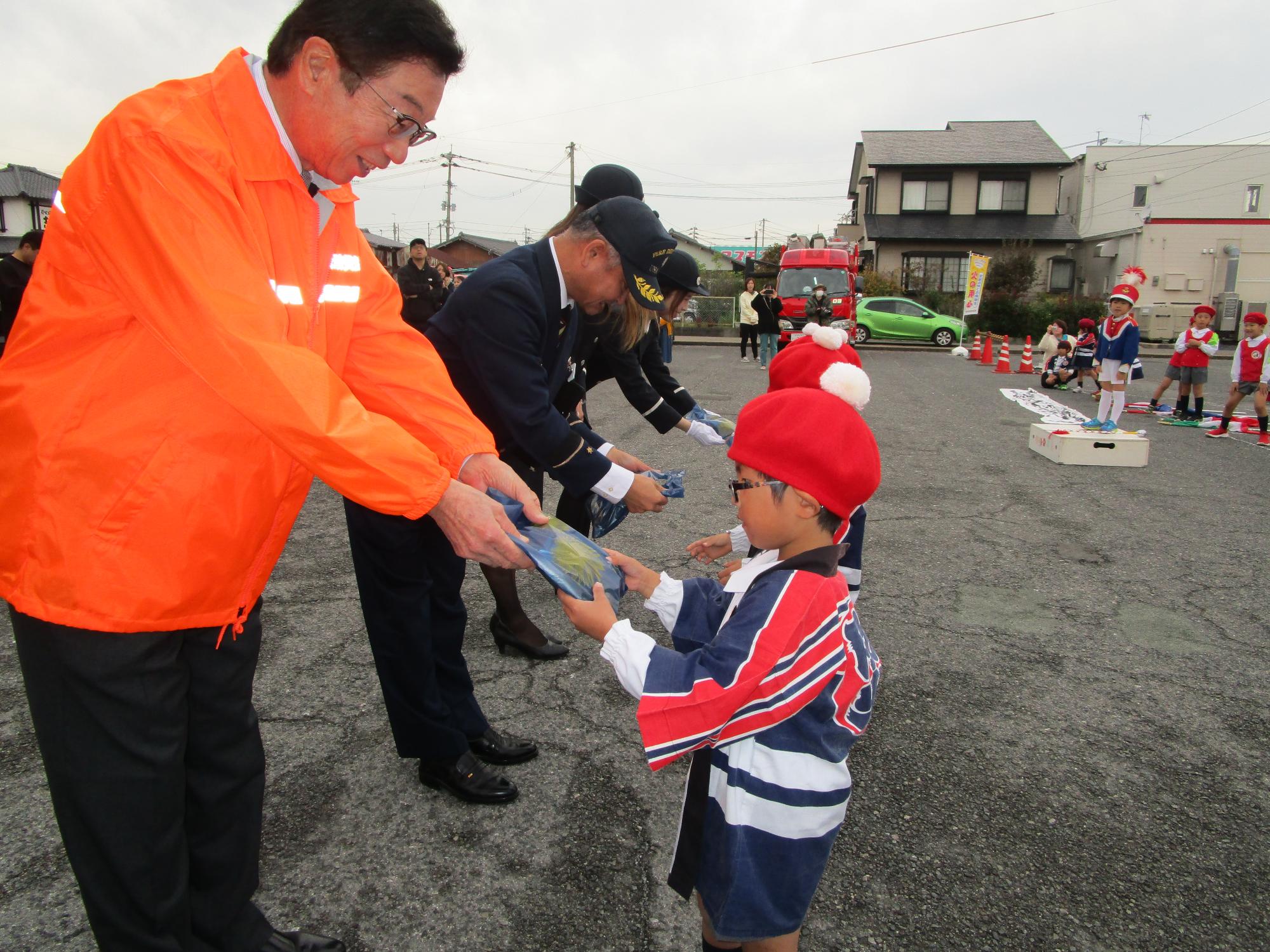 関係者から記念品を受け取る園児たちの写真