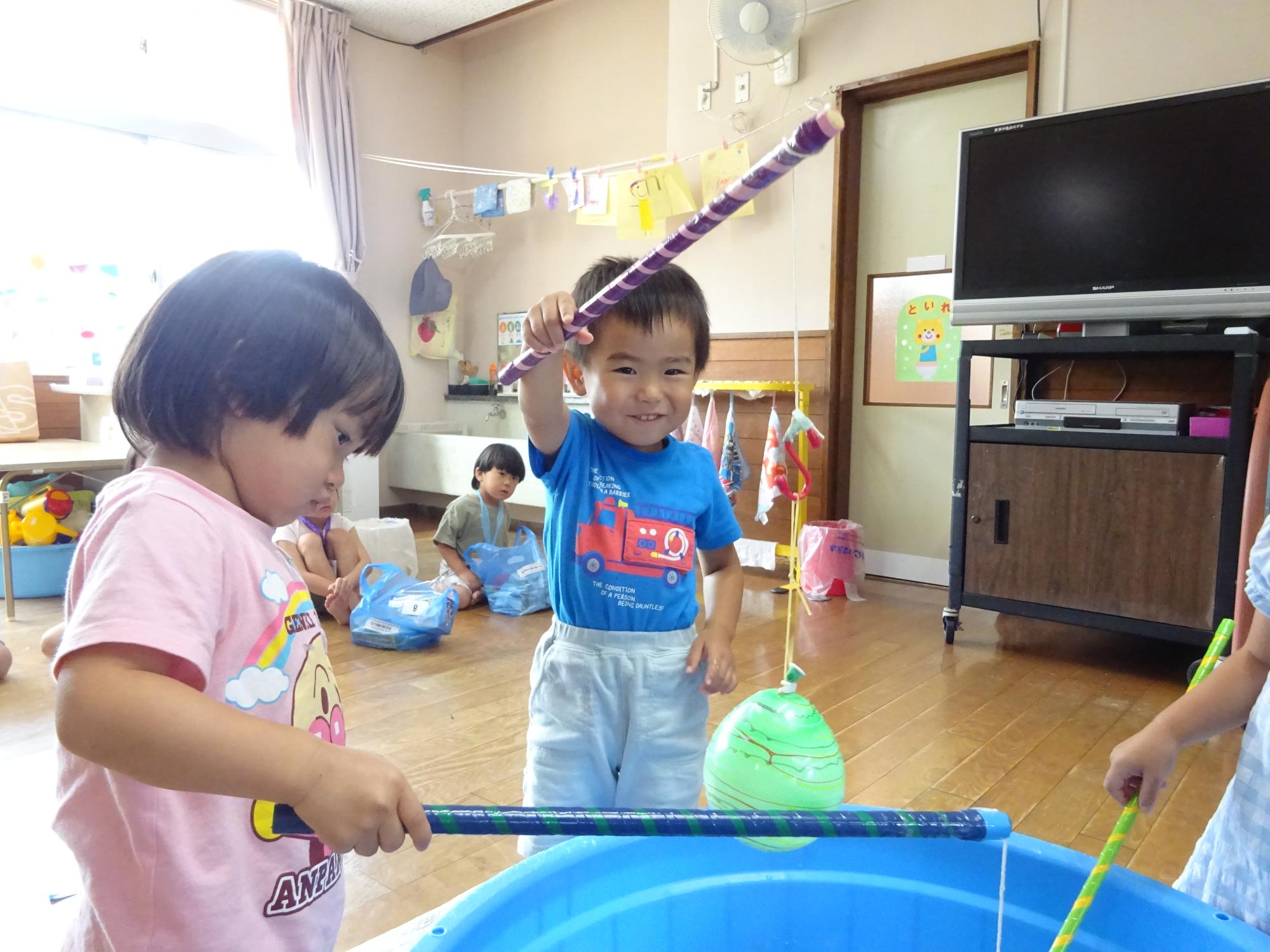 釣れたヨーヨーを見せる子ども