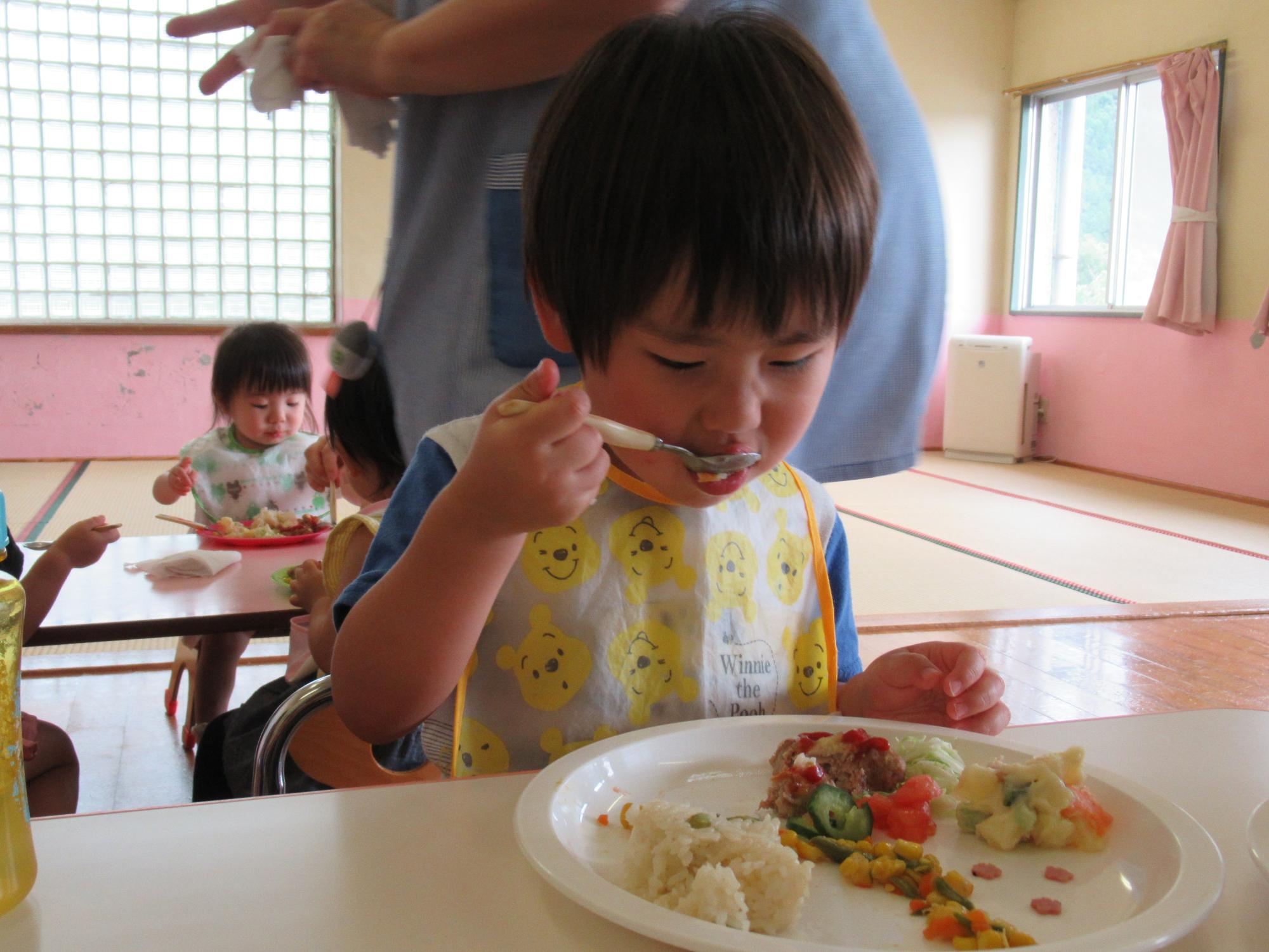 ランチプレートを頬張る2歳児