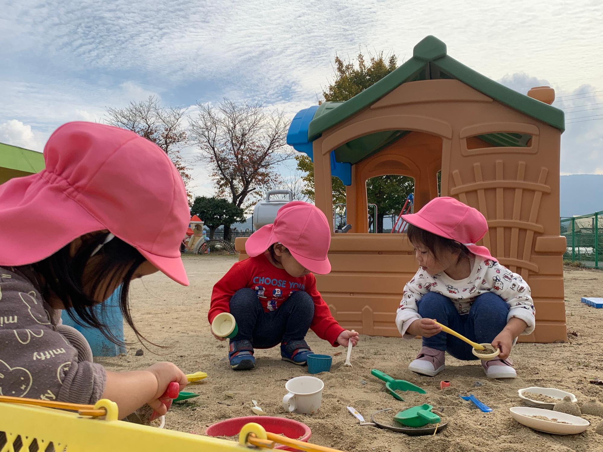 ハウスの前で遊ぶ1歳児
