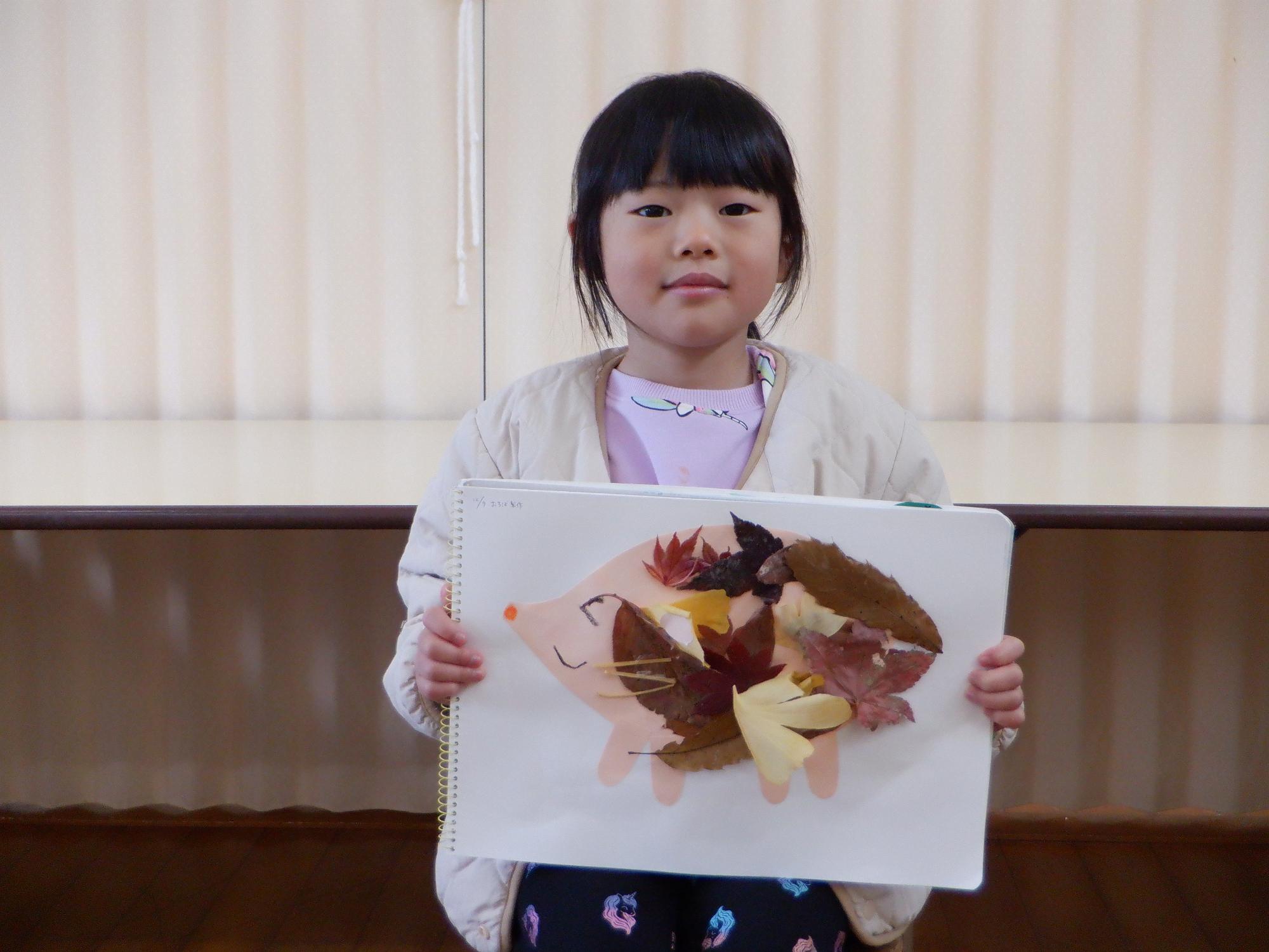 子ども、紅葉した葉っぱをハリネズミの模様にして体に貼る、イチョウ紅葉など赤黄色色の葉っぱ