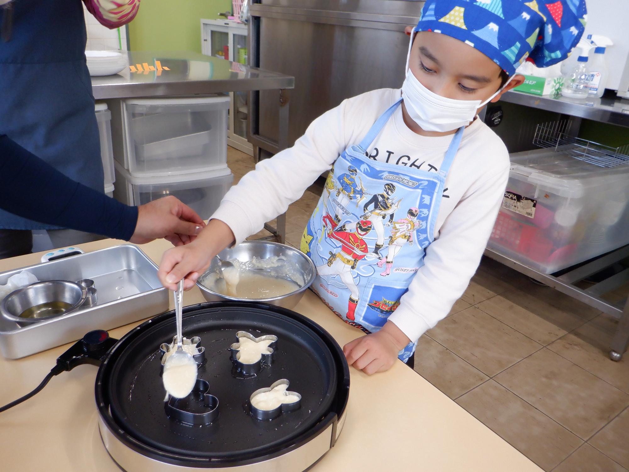 ホットケーキを焼く子ども、いろんな形うさぎ・ハート・小人型に流し作る