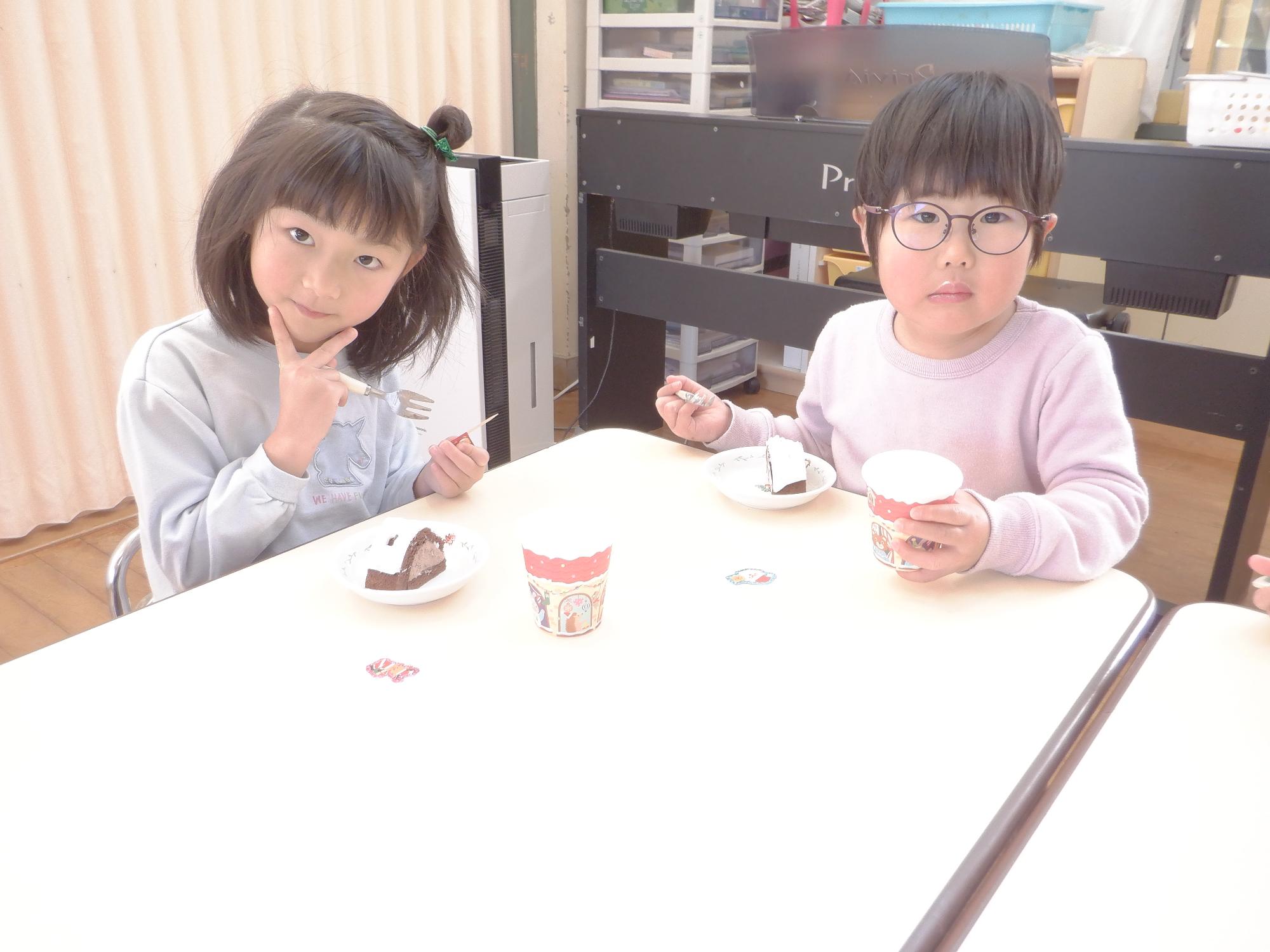 クリスマスケーキを食べる子供たち、ピースサインをしています