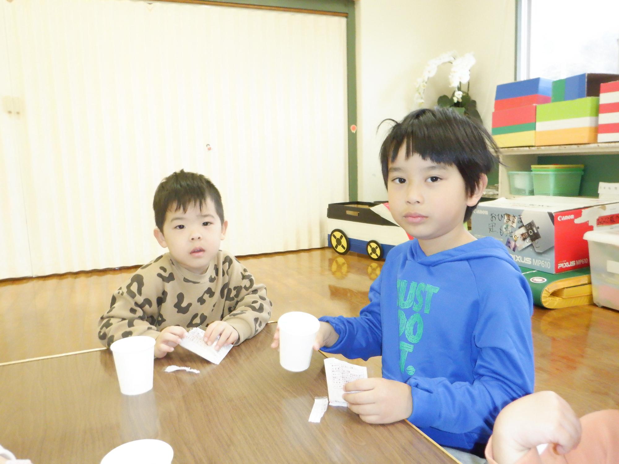 雛あられとカルピスを飲む男の子2人