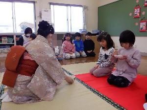 お茶会をする、着物姿の保育士がお茶を振舞う、お菓子を頂く女の子