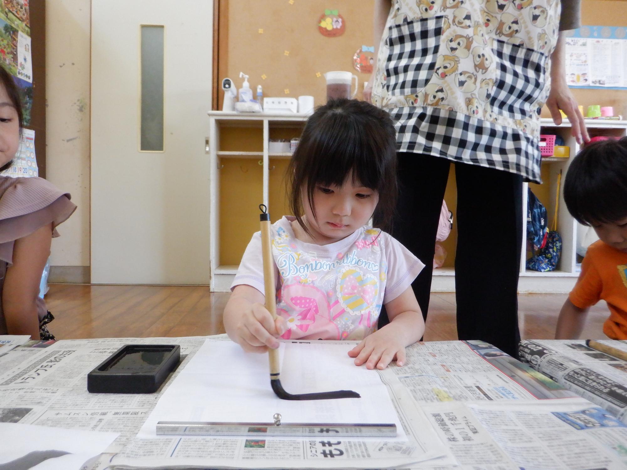 習字をする女の子、大という字に挑戦