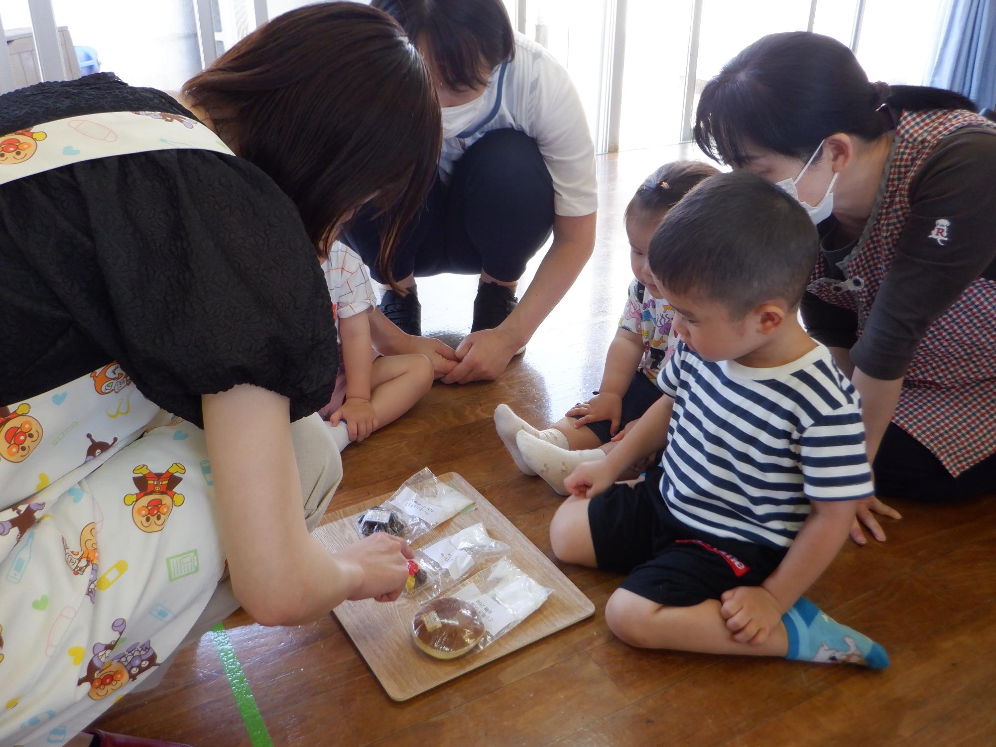 食品の砂糖含有量を見ている子どもたち、真剣な眼差しでどら焼き飴チョコレートを見ている
