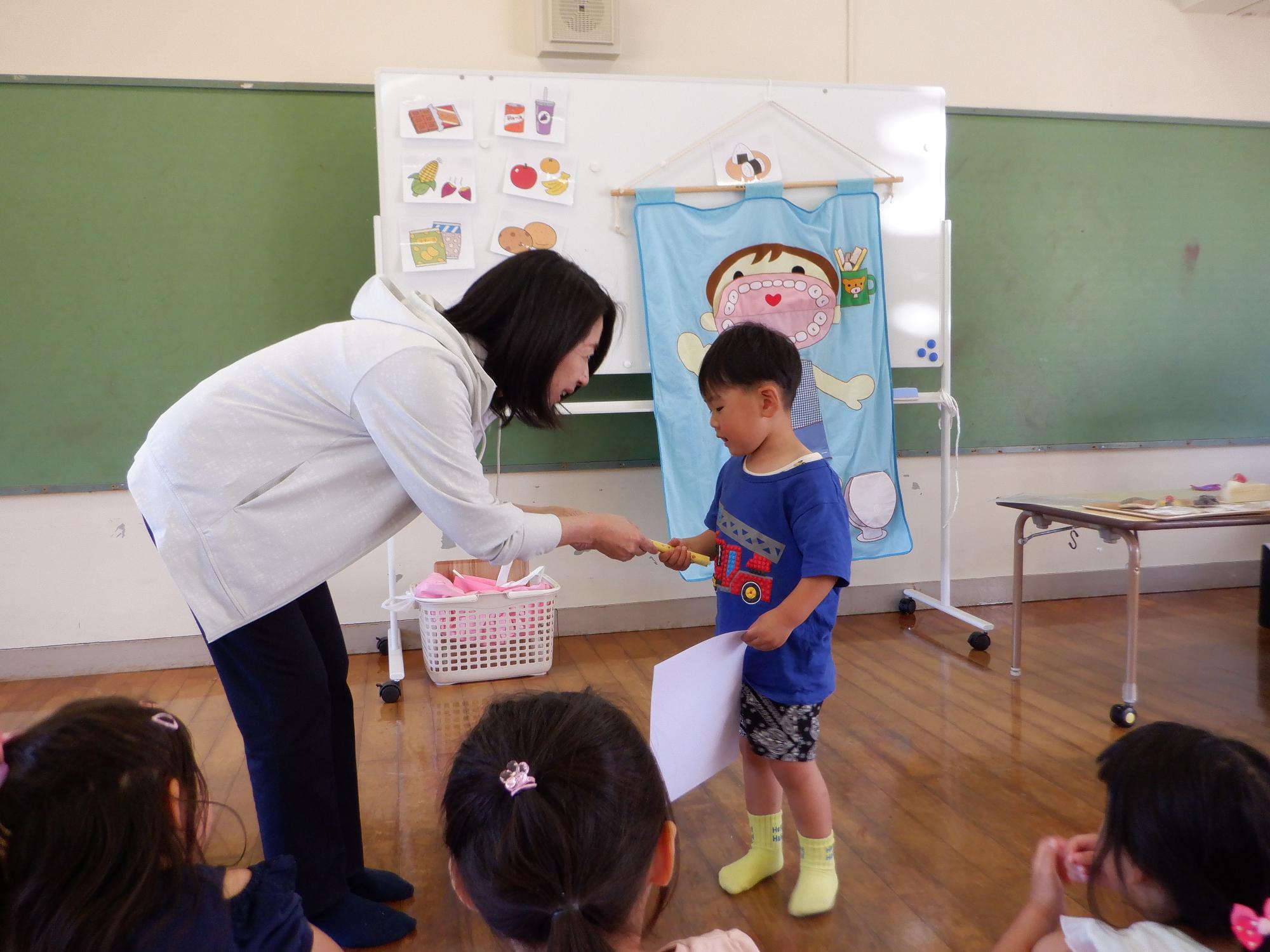 虫歯の無い子どもの表彰、賞状と歯ブラシのプレゼントをもらう