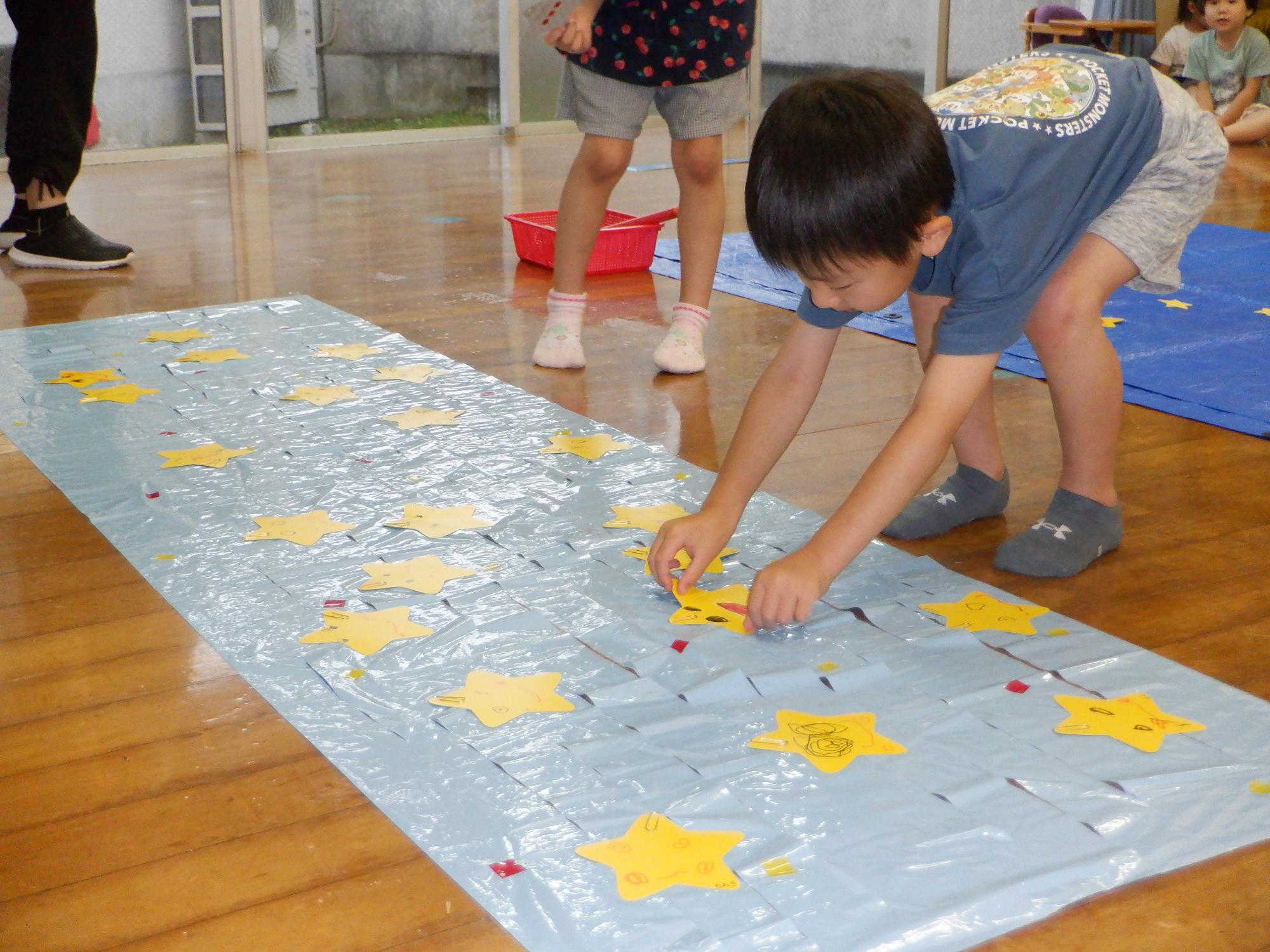 星を夜空につけてます、星がいっぱいになりました、男の子が貼ってます、