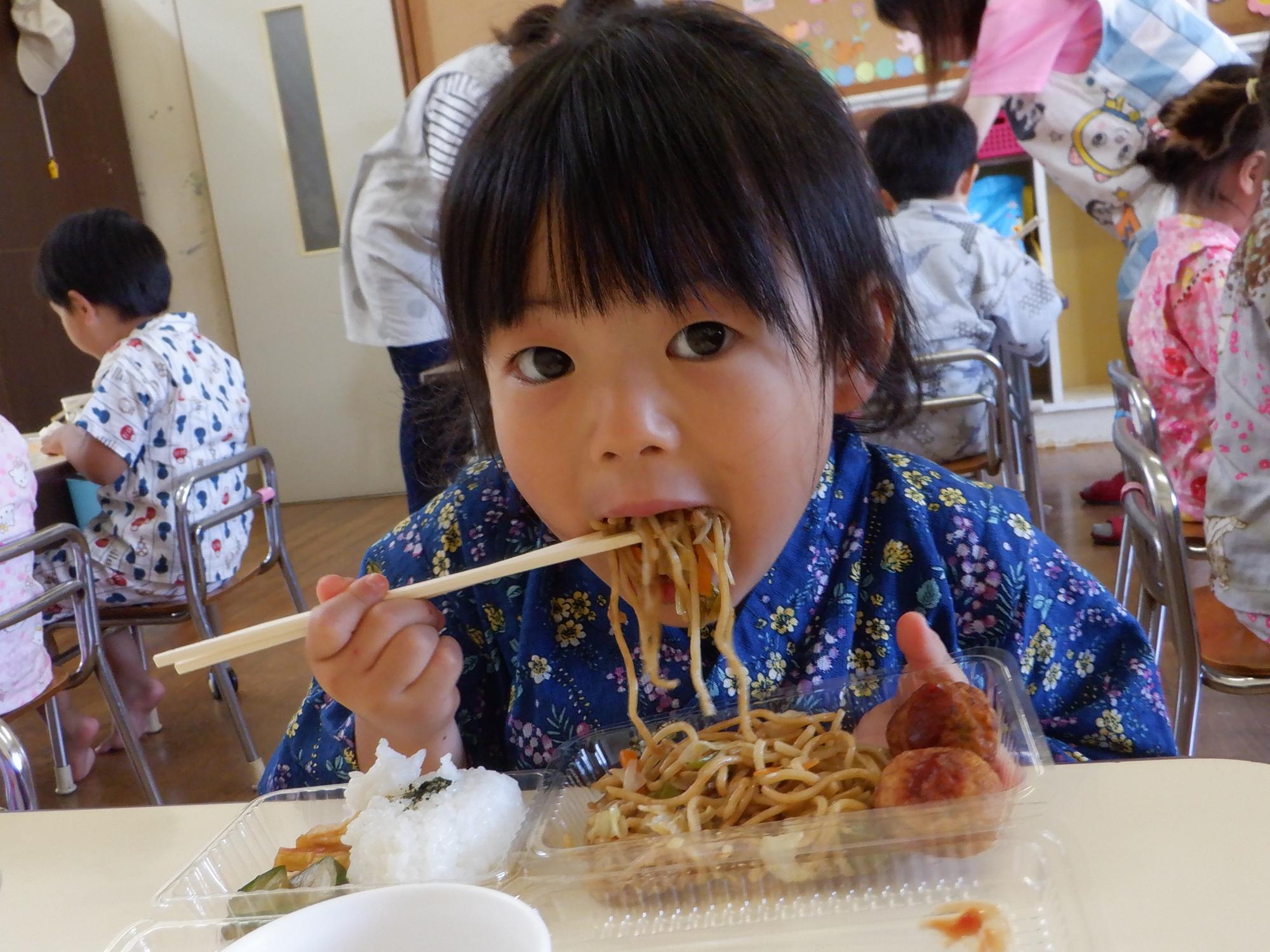 お祭り気分で焼きそば食べる女の子