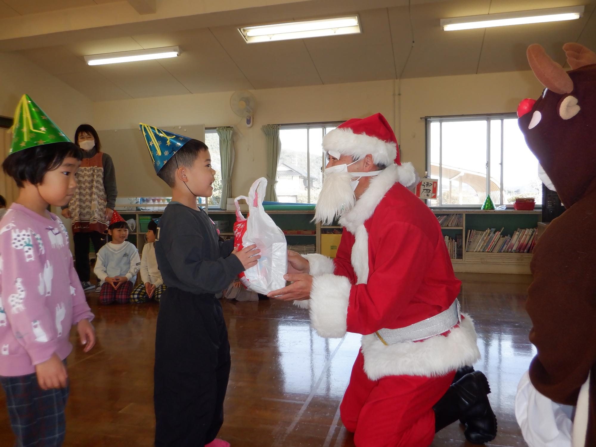 サンタさんからプレゼントを受け取る子ども、嬉しそうにしている子供たち