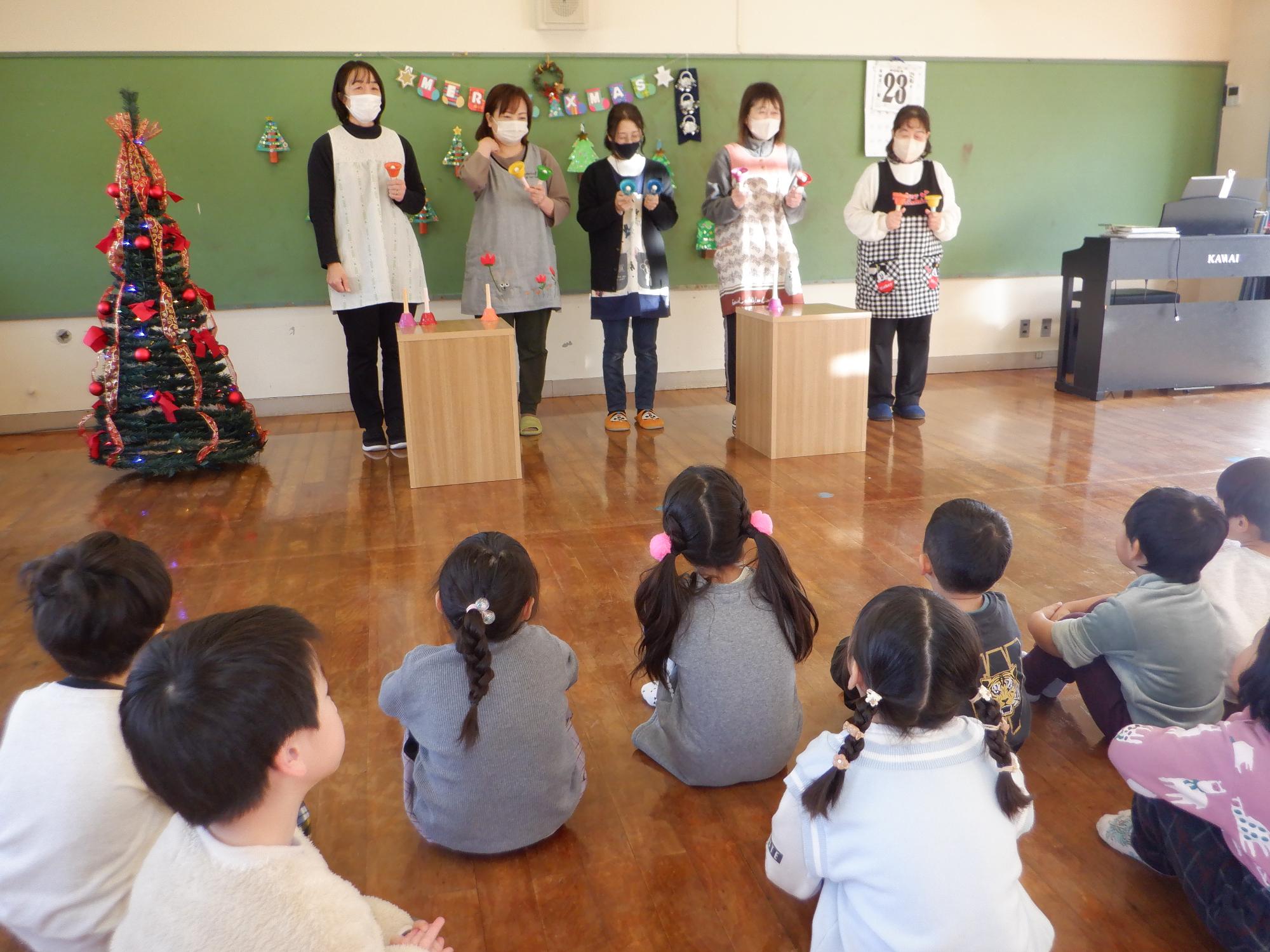 ハンドベル演奏をする保育者、子どもたちしっかり聞いている