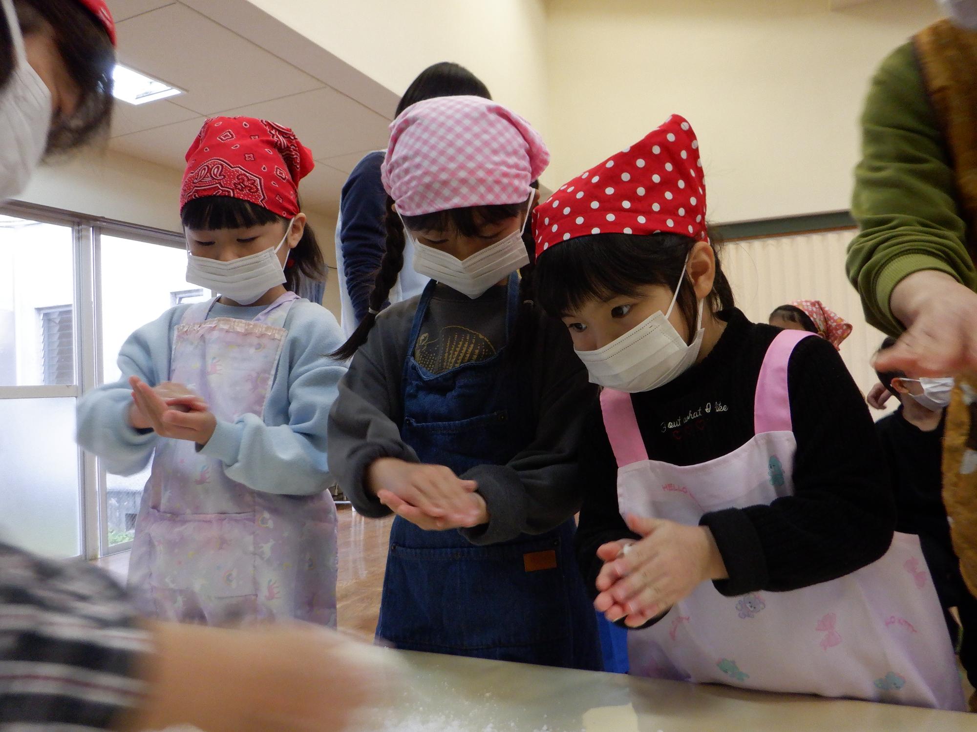 お餅を丸める子どもたち、上手に優しく丸めている女の子3人