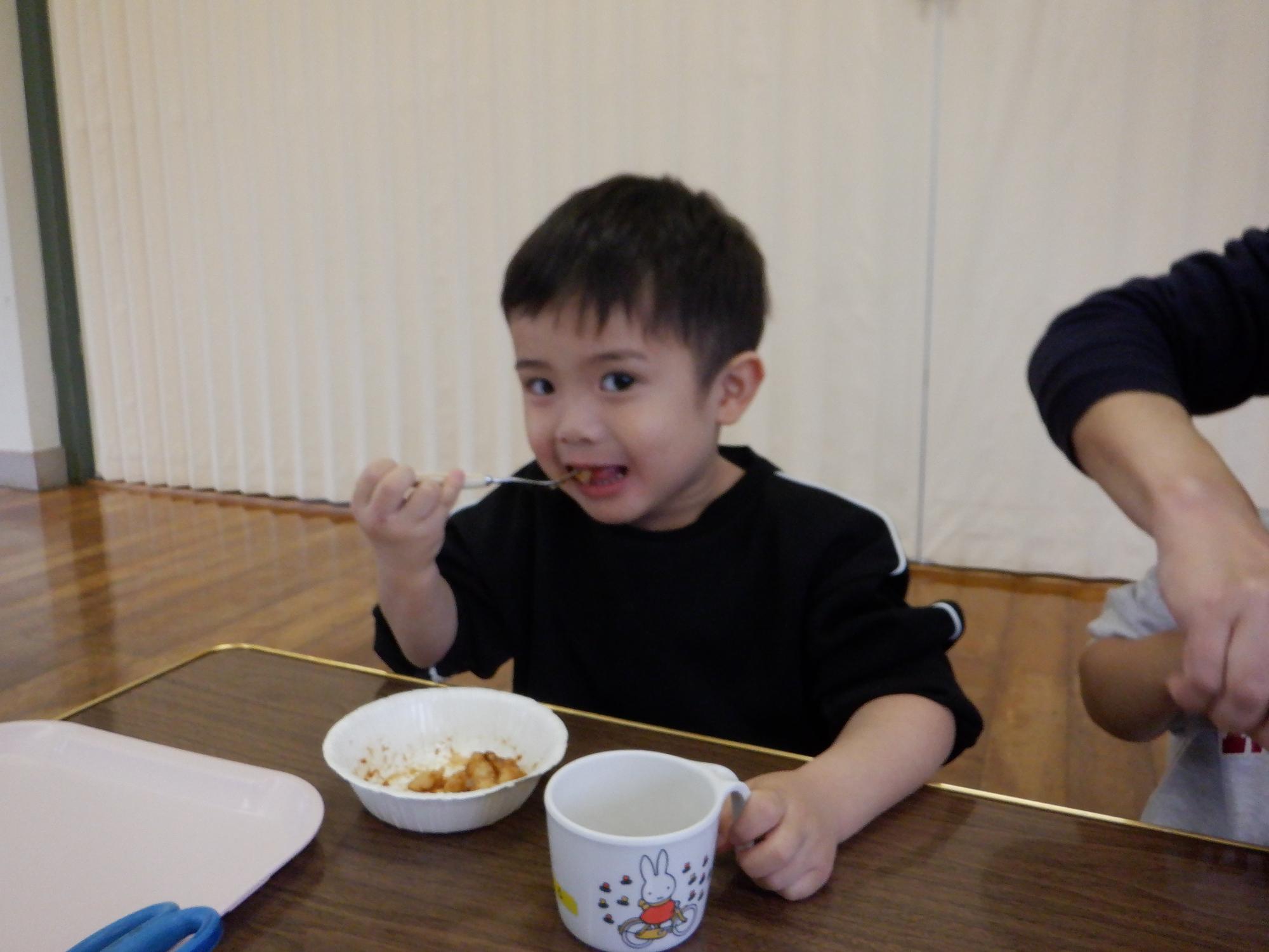 お餅を食べる子ども、黄粉もちを小さく切って食べている