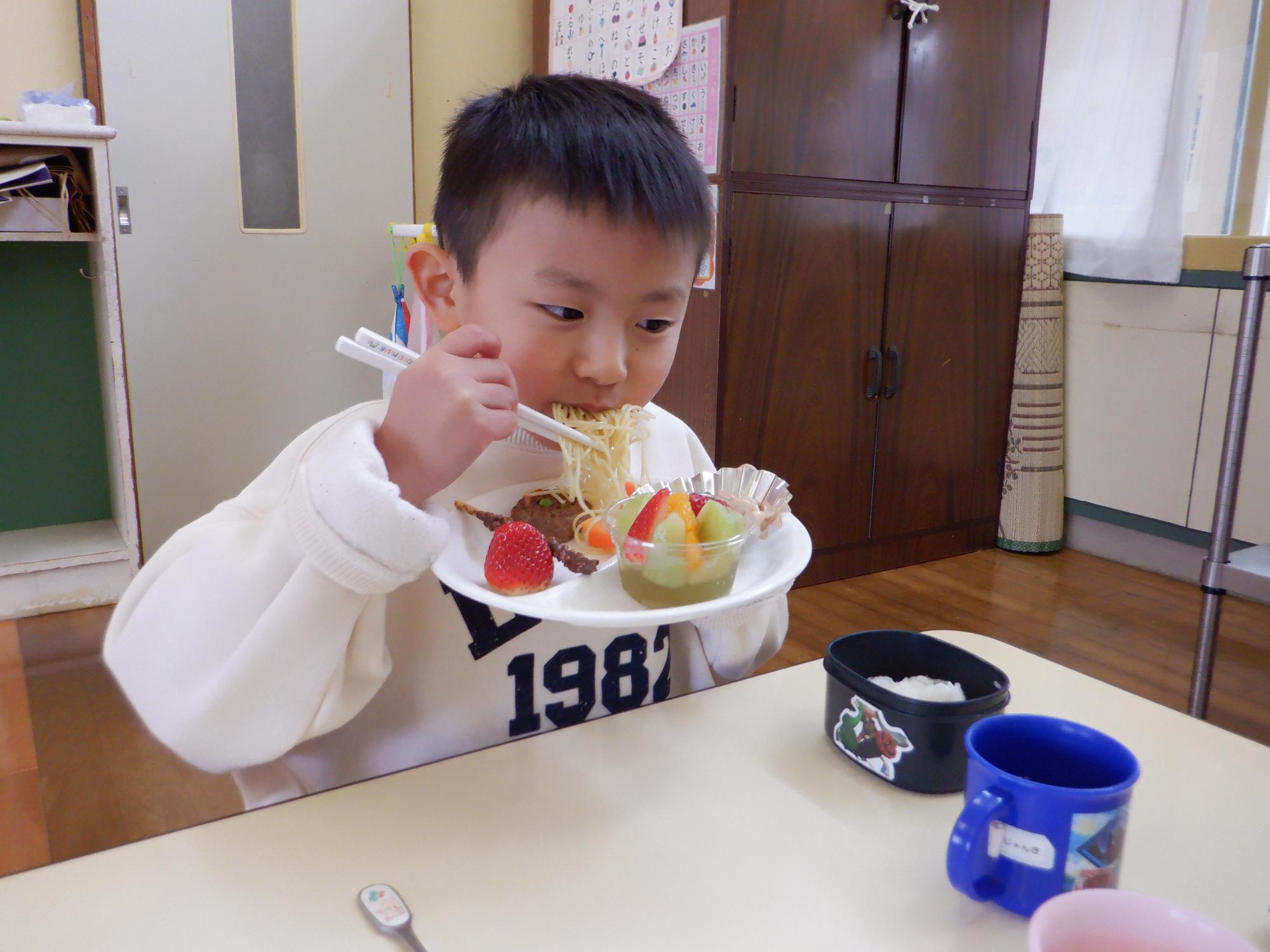 節分のプレートランチ、鬼の紙に見立てたスパゲッティを頬張る男の子、鬼バーグも美味しそう