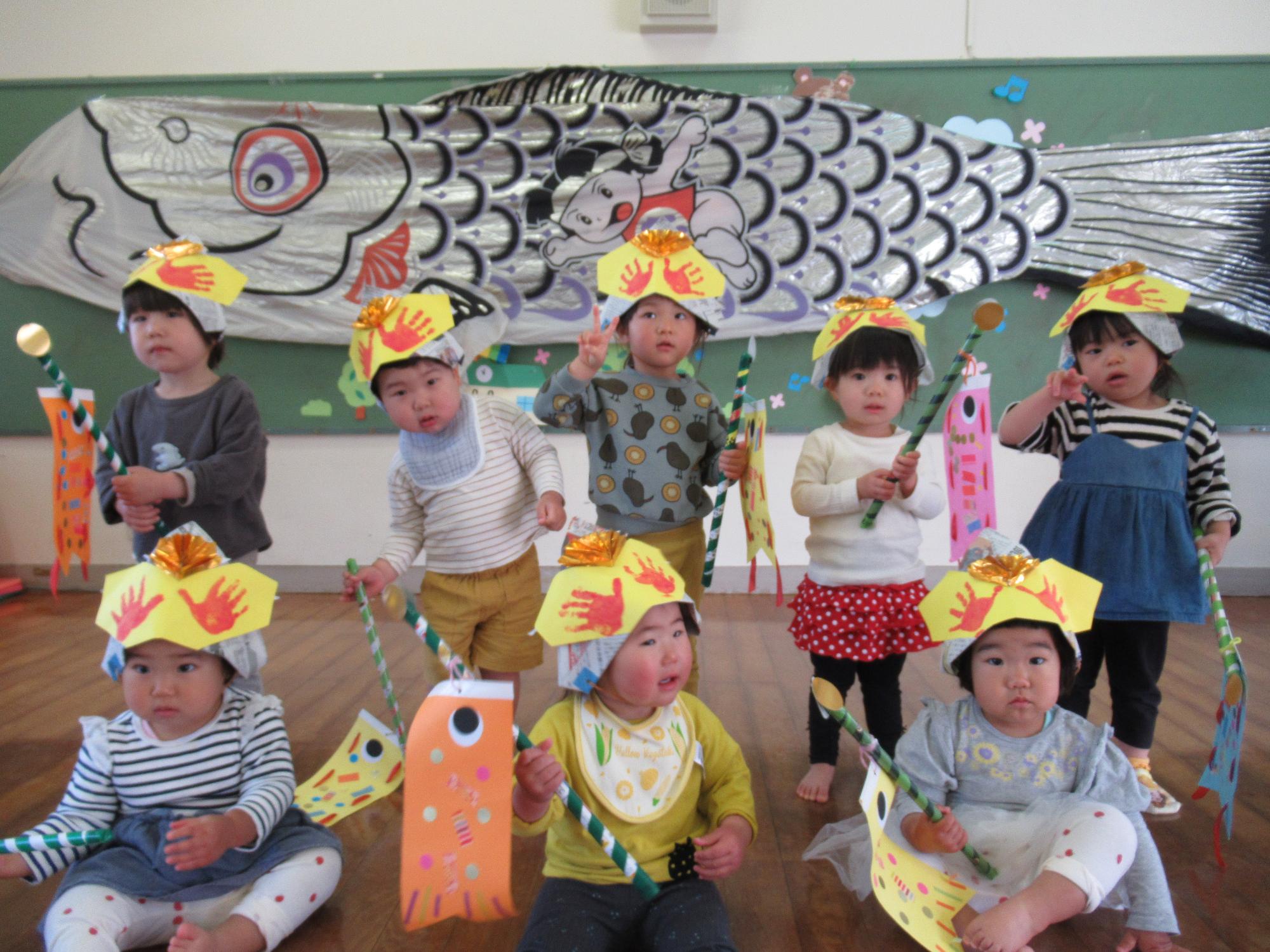 つぼみ組の子ども達、こいのぼりと兜をかぶる、手形やシールでカラフル飾り、