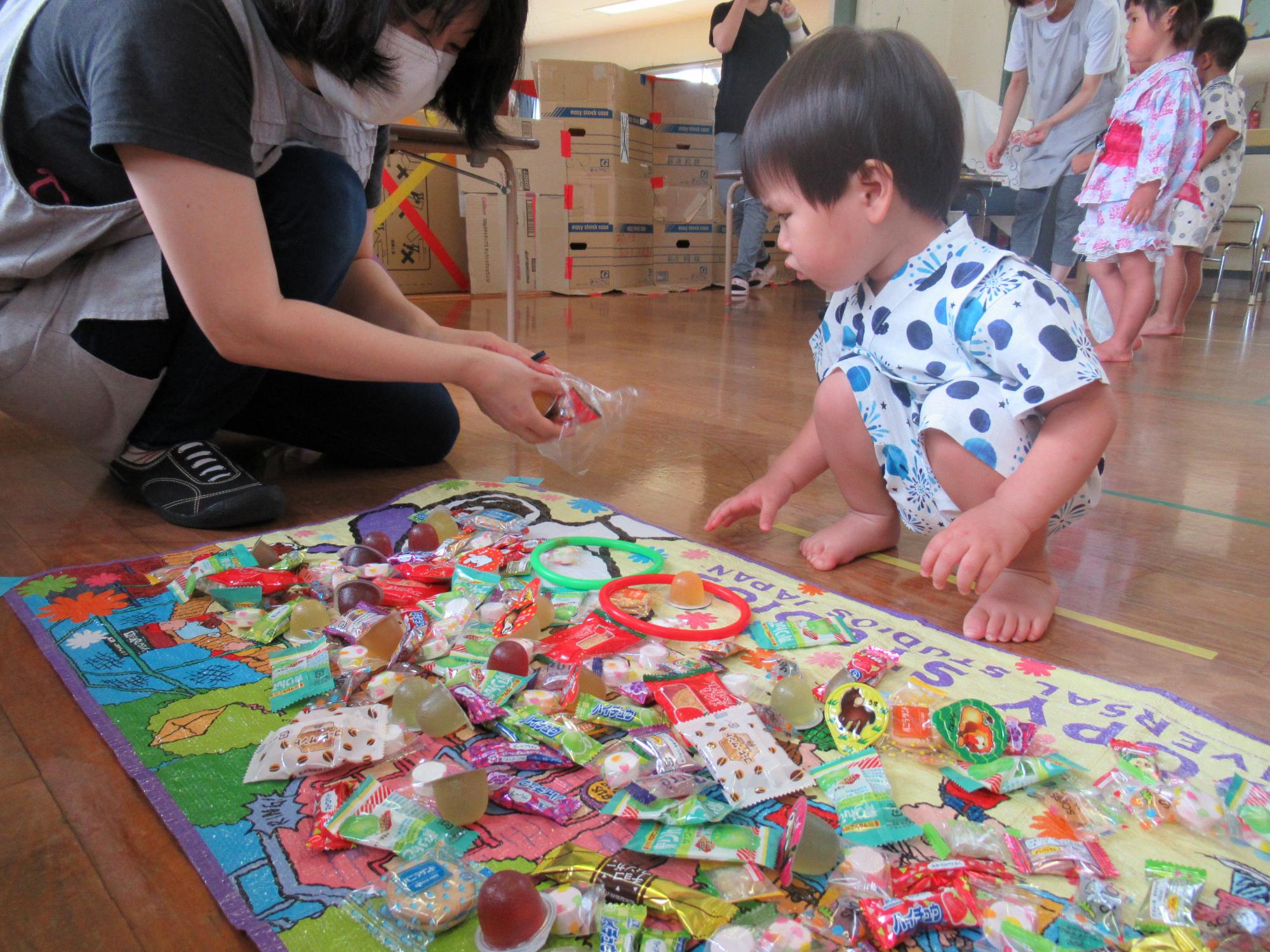 輪投げをしてお菓子をもらう男の子