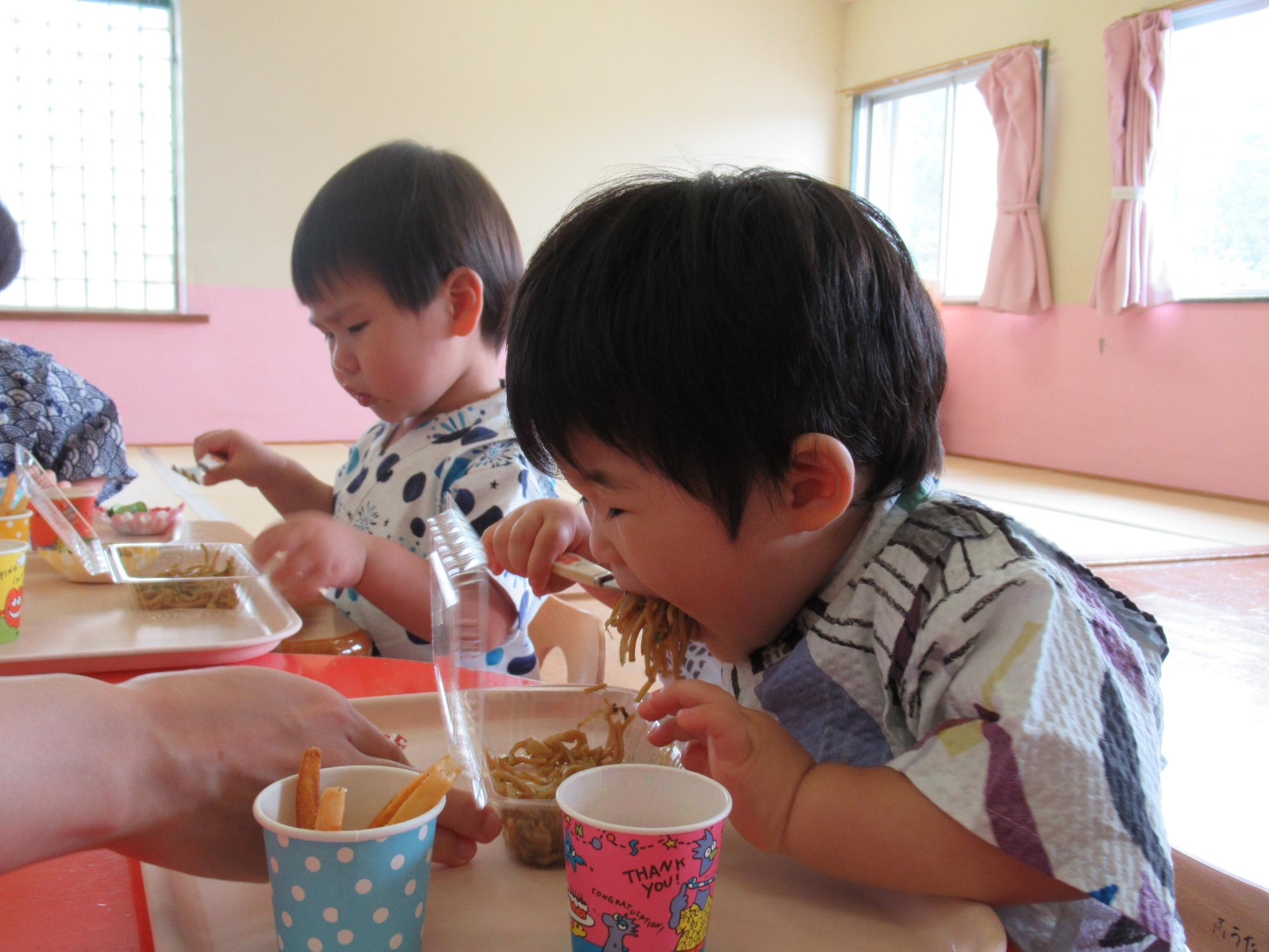 焼きそばを頬張る男の子