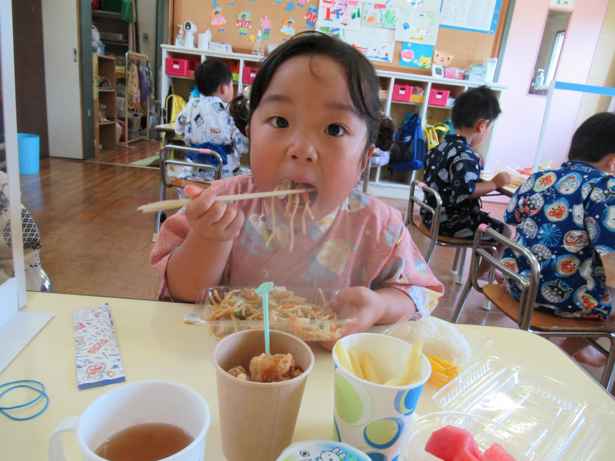 大きな口で焼きそばを食べる女の子