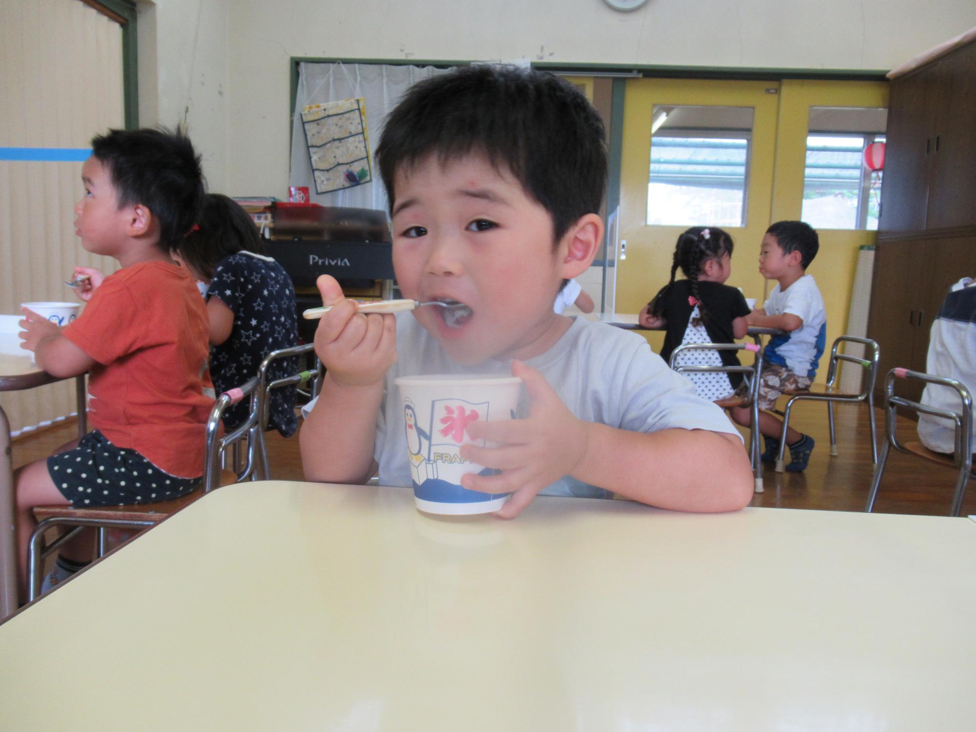 かき氷を冷たそうに食べる男の子