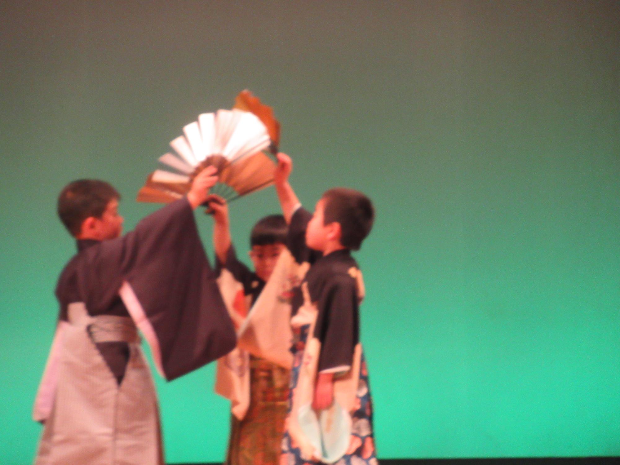 年長男の子袴姿に扇子を持ち、舞台で踊ってます。