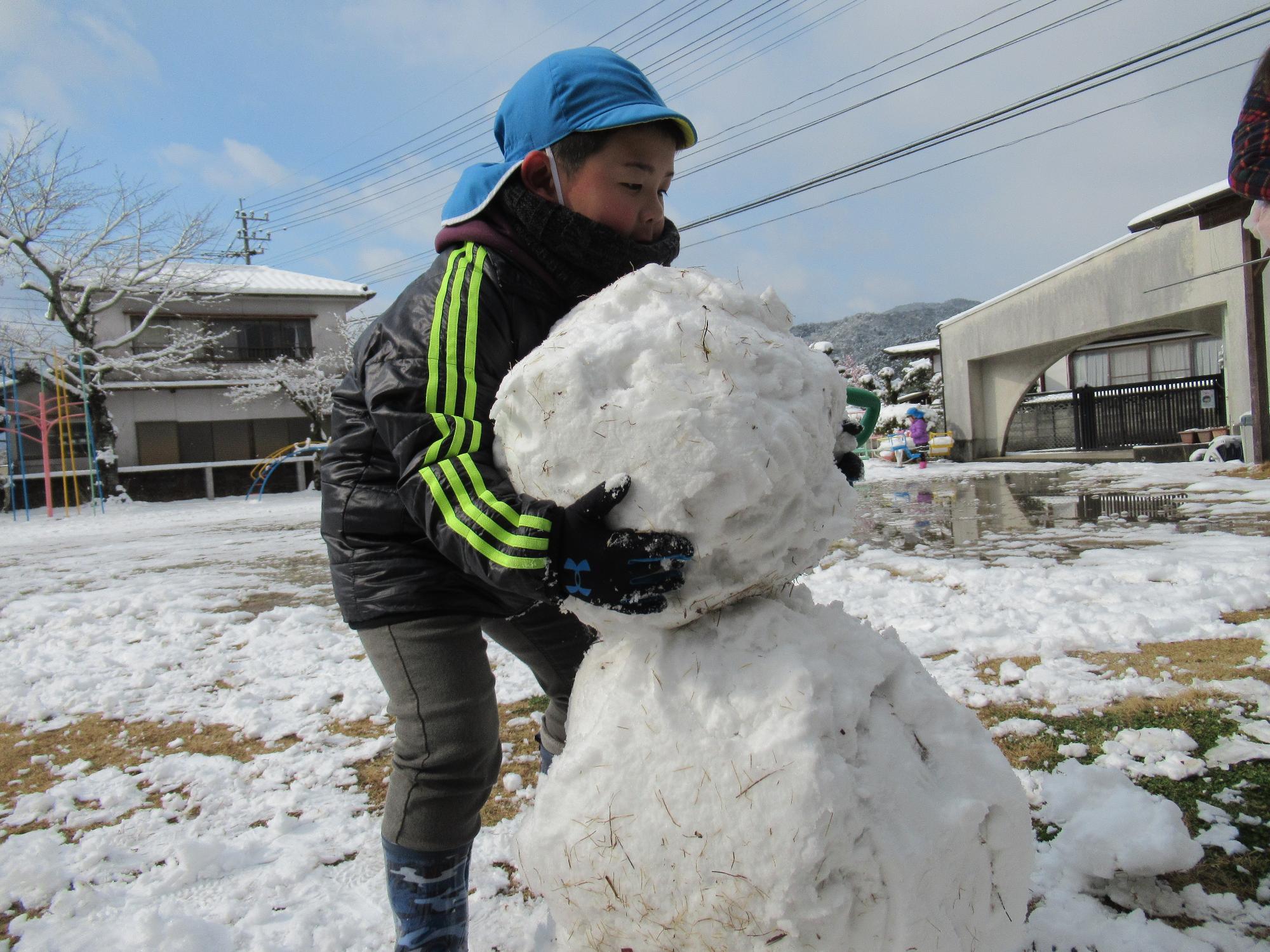 雪だるまの頭をのせる年長さん