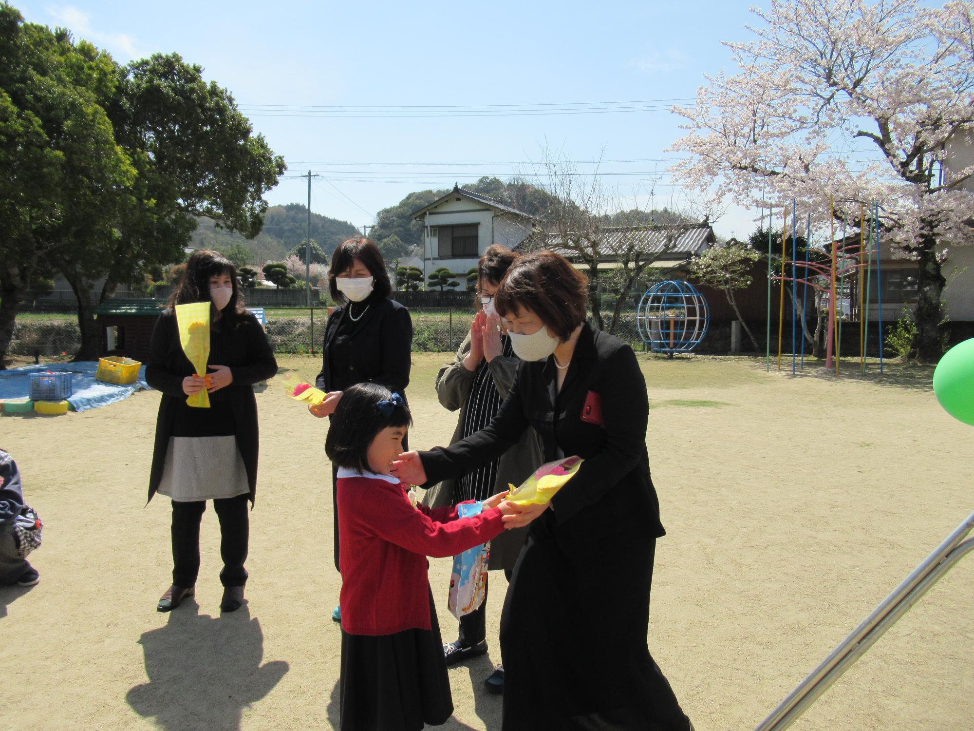 職員に花を渡す卒園児