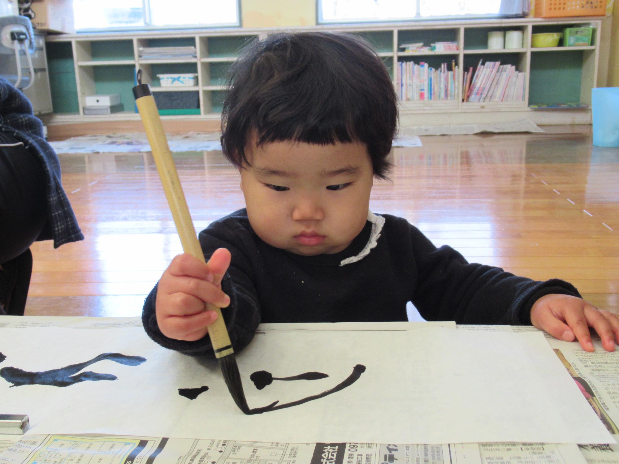 1歳の女の子、書初め、真剣に書に向かう