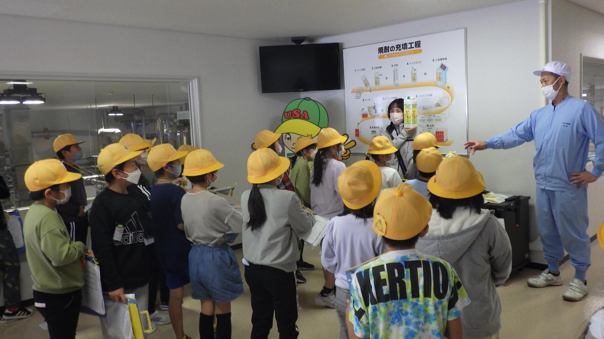 パック充填についての説明を聞く子供たち