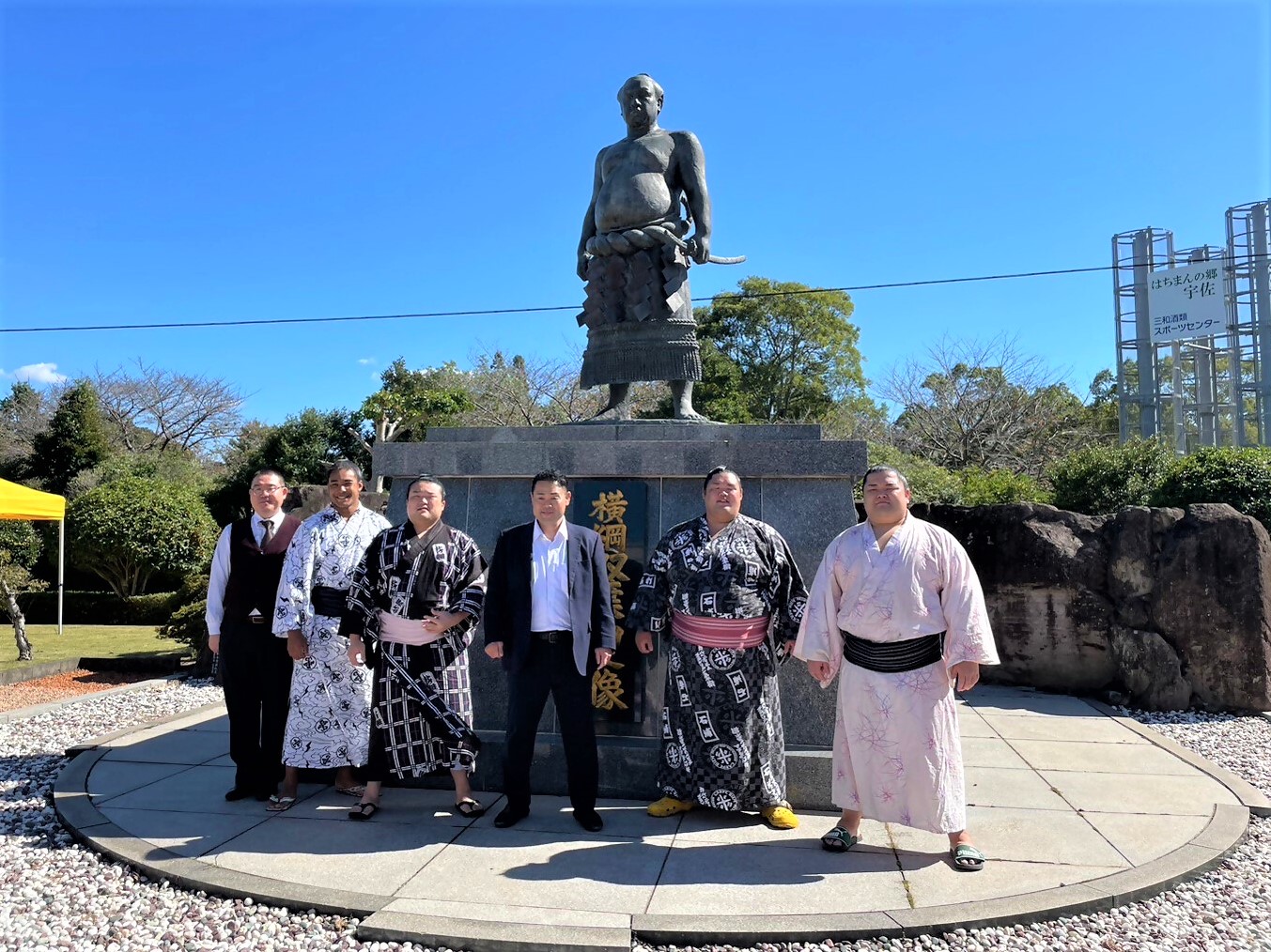 双葉山像の前で記念撮影をする雷部屋
