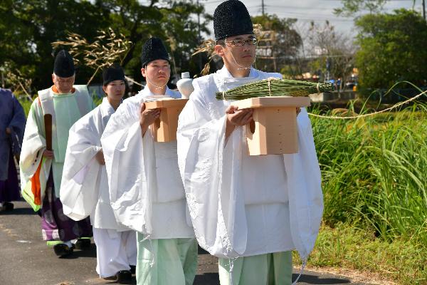 大祭を終え葦苞とともに寄藻川の河口へ向かう神職