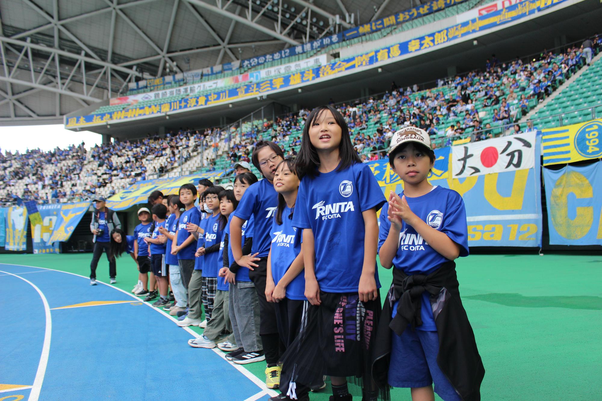 選手たちのウォーミングアップを見学する児童